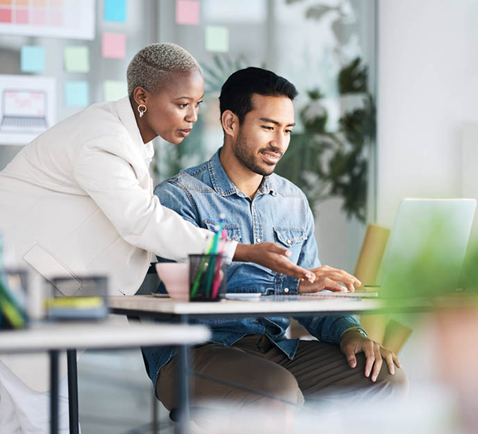 Un manager qui accompagne son collaborateur dans le changement sur un ordinateur